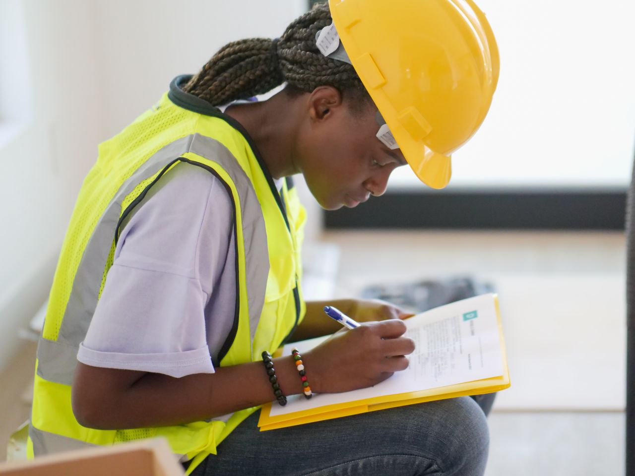 Inspector in a hard hat reviewing a property inspection checklist